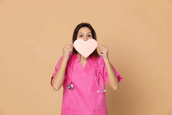Joven Médico Vistiendo Uniforme Rosa Sobre Fondo Amarillo —  Fotos de Stock