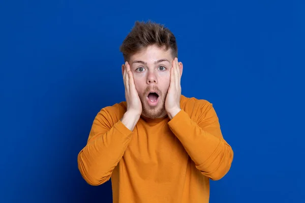 Aantrekkelijke Jongeman Met Een Geel Shirt Een Blauwe Achtergrond — Stockfoto