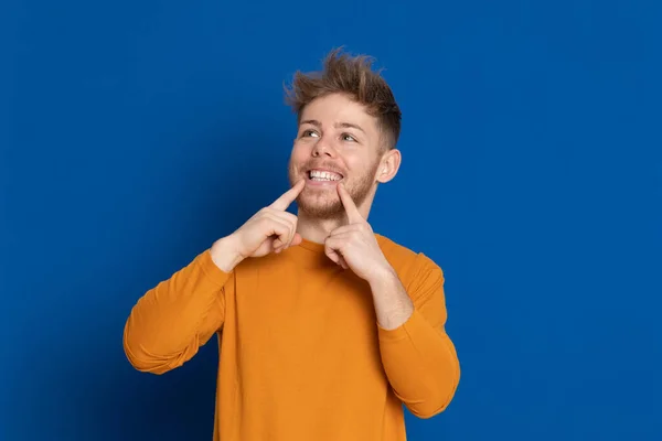 Aantrekkelijke Jongeman Met Een Geel Shirt Een Blauwe Achtergrond — Stockfoto