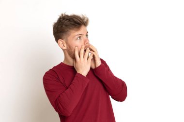 Beyaz arka planda kırmızı tişörtlü çekici bir genç.