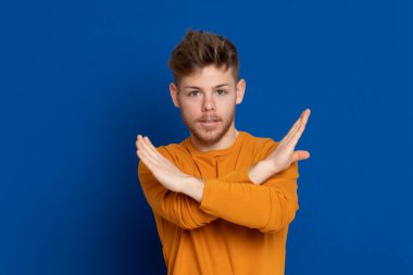 Mavi arka planda sarı tişörtlü çekici bir genç.