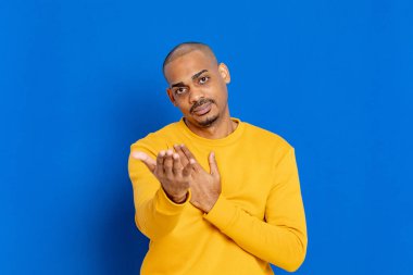 Mavi arka planda sarı formalı Afrikalı adam.