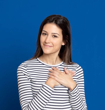 Stüdyoda mavi arka planda çekici esmer kız.