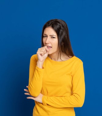 Stüdyoda mavi arka planda çekici esmer kız.