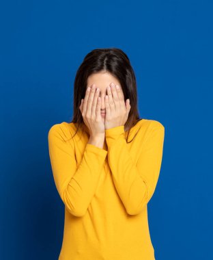 Stüdyoda mavi arka planda çekici esmer kız.