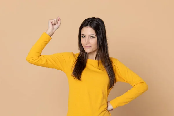 魅力的な若いです女の子身に着けていますA Tシャツ上の黄色の背景 — ストック写真