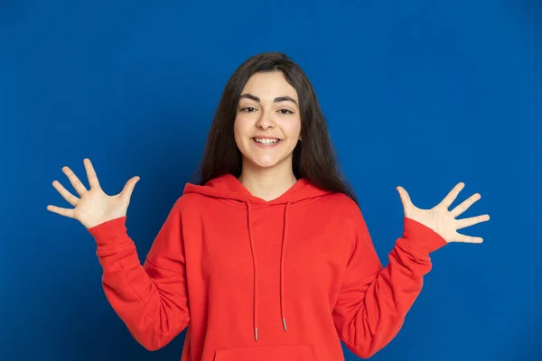 Brunette Jong Meisje Met Een Rode Trui Een Blauwe Achtergrond — Stockfoto