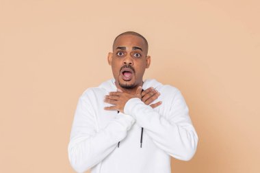 Sarı arka planda beyaz kazaklı Afrikalı bir adam.