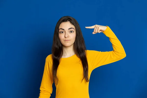 Brunette Jong Meisje Draagt Gele Trui Een Blauwe Achtergrond — Stockfoto