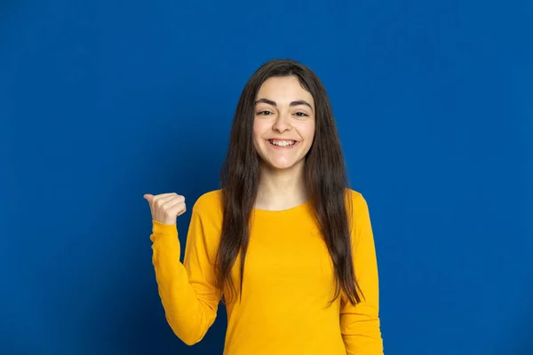 Chica Joven Morena Con Jersey Amarillo Sobre Fondo Azul — Foto de Stock