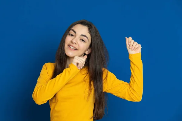 Chica Joven Morena Con Jersey Amarillo Sobre Fondo Azul —  Fotos de Stock