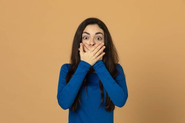 Sarı arka planda mavi forma giyen esmer genç kız.