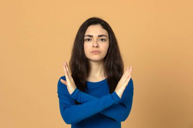 Sarı arka planda mavi forma giyen esmer genç kız.