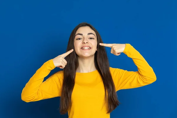 Chica Joven Morena Con Jersey Amarillo Sobre Fondo Azul —  Fotos de Stock