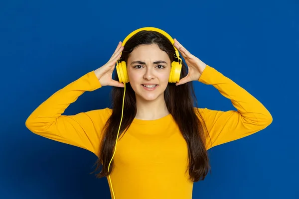 Chica Joven Morena Con Jersey Amarillo Sobre Fondo Azul —  Fotos de Stock