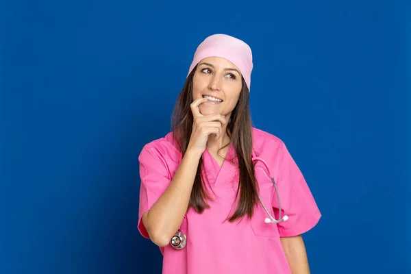 Médico Joven Con Uniforme Rosa Sobre Fondo Azul — Foto de Stock