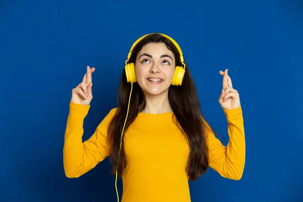 Chica Joven Morena Con Jersey Amarillo Sobre Fondo Azul —  Fotos de Stock