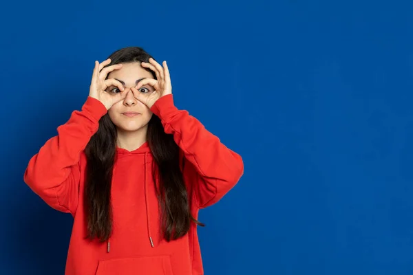 Brunette Jong Meisje Draagt Rode Trui Een Blauwe Achtergrond Rechtenvrije Stockafbeeldingen