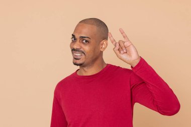 Sarı arka planda kırmızı formalı Afrikalı adam.