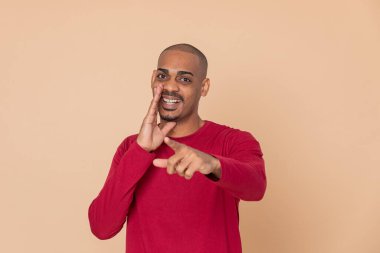 Sarı arka planda kırmızı formalı Afrikalı adam.