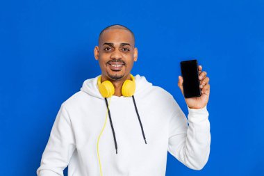 Mavi arka planda beyaz bir kazak giyen Afrikalı adam.