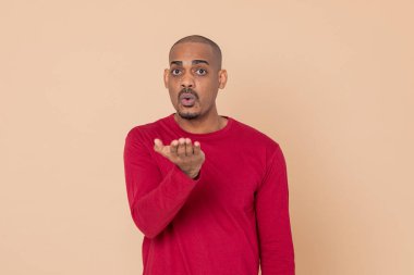 Sarı arka planda kırmızı formalı Afrikalı adam.