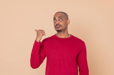 Sarı arka planda kırmızı formalı Afrikalı adam.