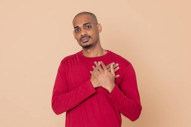 Sarı arka planda kırmızı formalı Afrikalı adam.