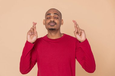 Sarı arka planda kırmızı formalı Afrikalı adam.