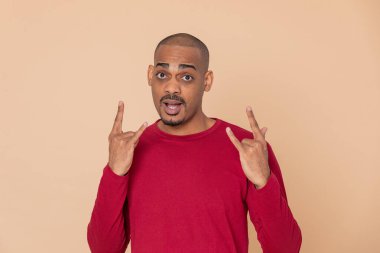 Sarı arka planda kırmızı formalı Afrikalı adam.