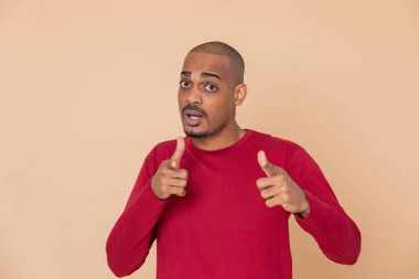 Sarı arka planda kırmızı formalı Afrikalı adam.