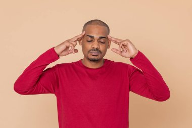 Sarı arka planda kırmızı formalı Afrikalı adam.