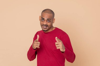 Sarı arka planda kırmızı formalı Afrikalı adam.