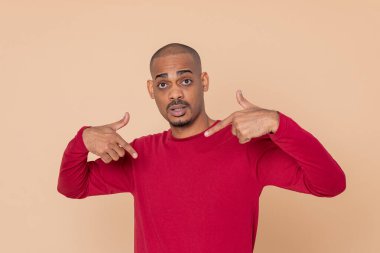 Sarı arka planda kırmızı formalı Afrikalı adam.