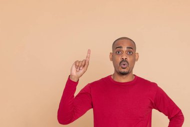 Sarı arka planda kırmızı formalı Afrikalı adam.