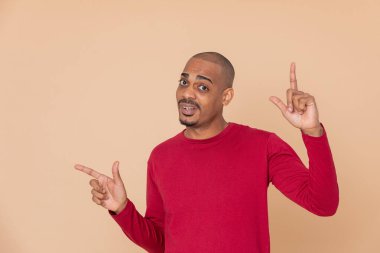 Sarı arka planda kırmızı formalı Afrikalı adam.