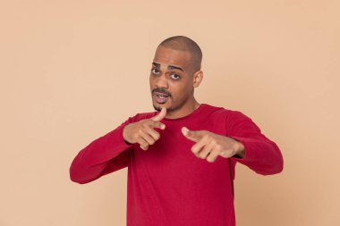 Sarı arka planda kırmızı formalı Afrikalı adam.