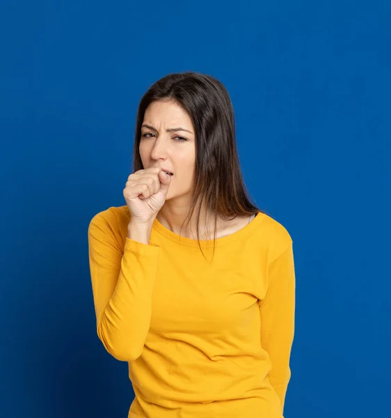 Brünette Junge Frau Mit Gelbem Shirt Auf Blauem Hintergrund — Stockfoto