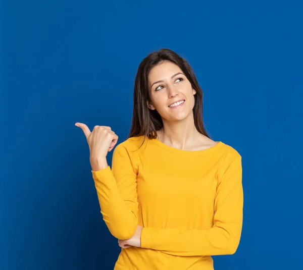 Mujer Joven Morena Con Una Camiseta Amarilla Sobre Fondo Azul —  Fotos de Stock