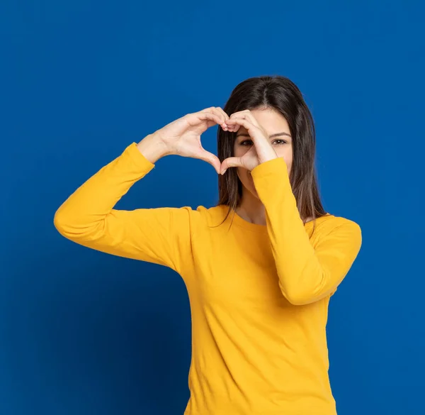 Μελαχρινή Νεαρή Γυναίκα Που Φοράει Ένα Κίτρινο Μπλουζάκι Μπλε Φόντο — Φωτογραφία Αρχείου