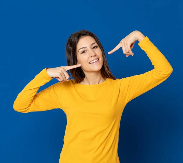 Mujer Joven Morena Con Una Camiseta Amarilla Sobre Fondo Azul —  Fotos de Stock