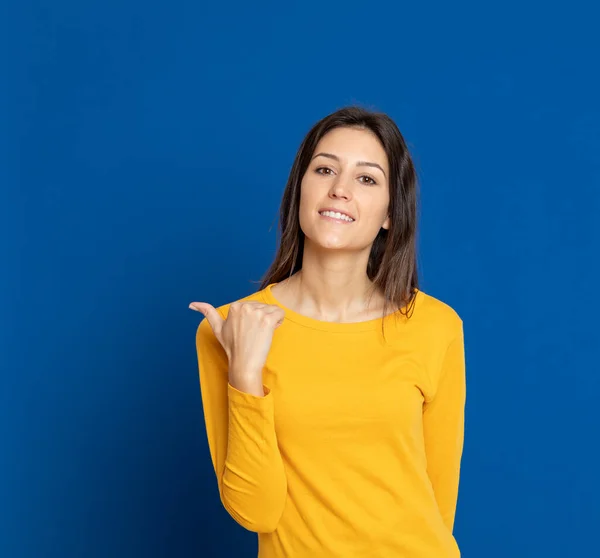 Mujer Joven Morena Con Una Camiseta Amarilla Sobre Fondo Azul — Foto de Stock