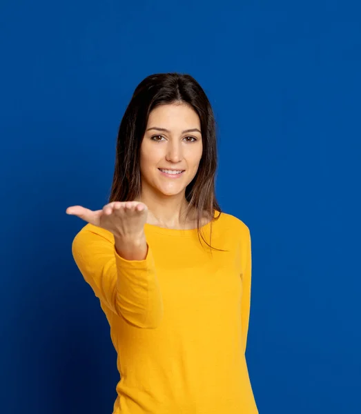 Brunette Jonge Vrouw Draagt Een Geel Shirt Een Blauwe Achtergrond — Stockfoto