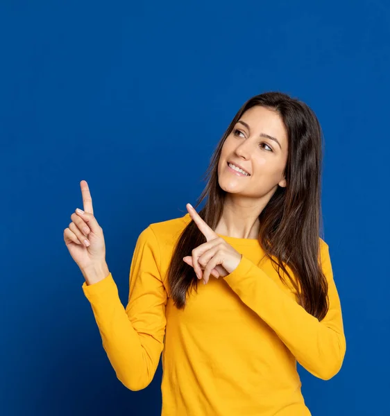 Mujer Joven Morena Con Una Camiseta Amarilla Sobre Fondo Azul —  Fotos de Stock