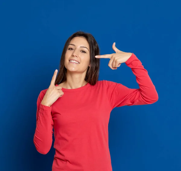 Mujer Joven Morena Con Una Camiseta Roja Sobre Fondo Azul —  Fotos de Stock