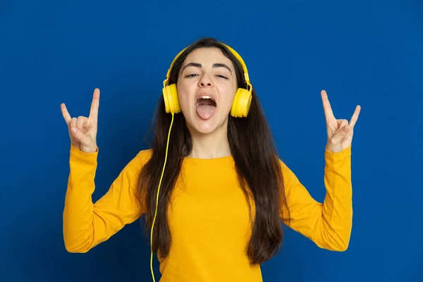 Chica Joven Morena Con Jersey Amarillo Sobre Fondo Azul —  Fotos de Stock