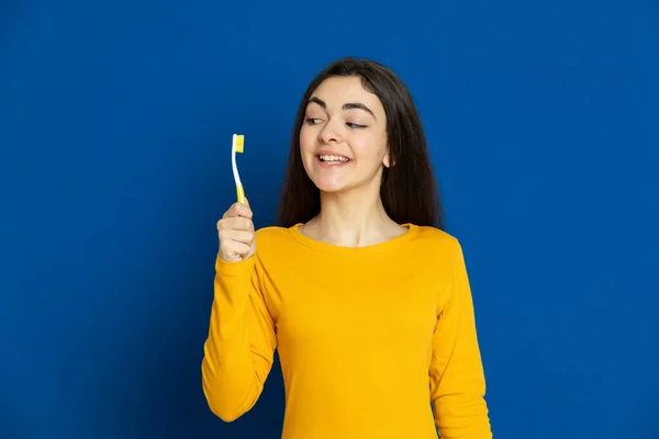 Brünettes Junges Mädchen Trägt Gelbes Trikot Auf Blauem Hintergrund — Stockfoto