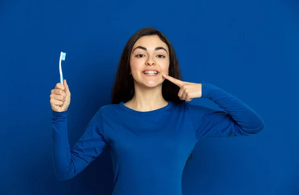 Brunette Jong Meisje Draagt Blauwe Trui Een Blauwe Achtergrond — Stockfoto