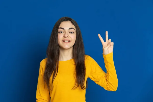 Brunette Jong Meisje Draagt Gele Trui Een Blauwe Achtergrond — Stockfoto