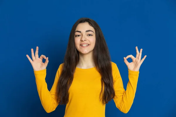 Brunette Jong Meisje Draagt Gele Trui Een Blauwe Achtergrond — Stockfoto